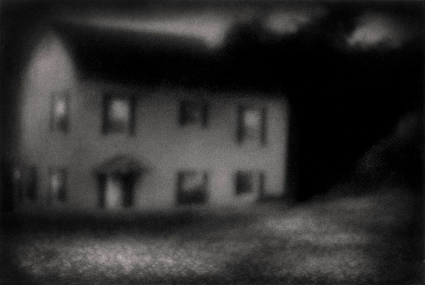 A blurry image of a house with trees in the background.
