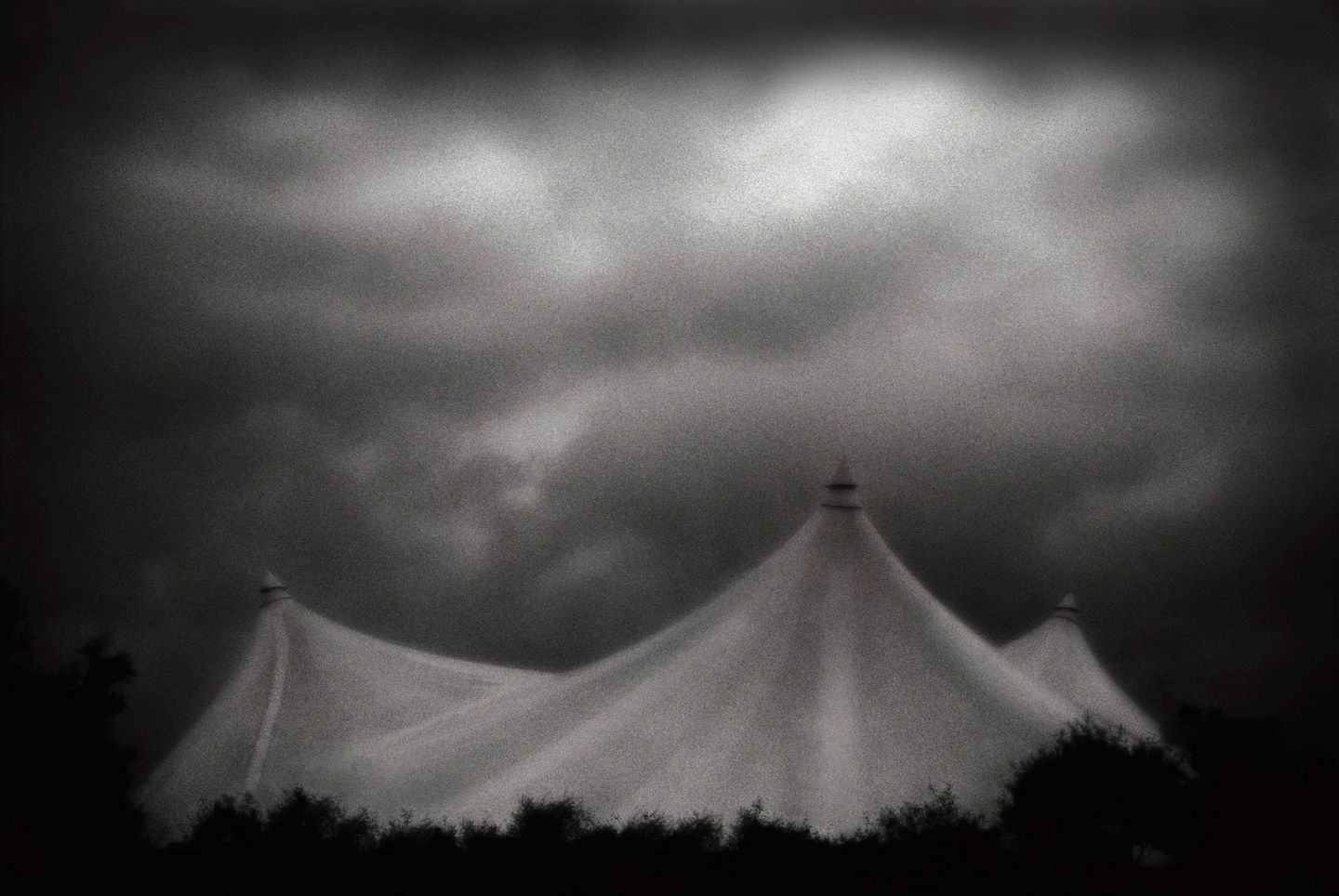 A tent in the middle of nowhere under dark clouds.