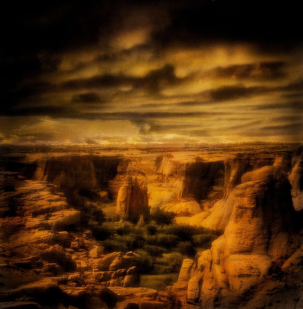 A painting of the desert with dark clouds overhead.