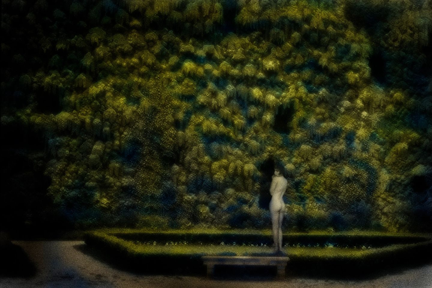 A blurry image of a person standing in front of a wall.
