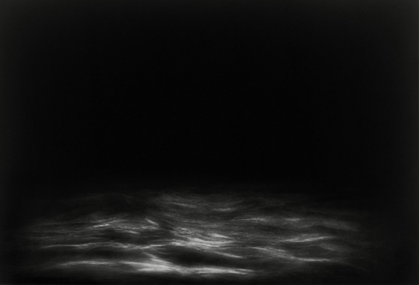 A black and white photo of some clouds in the dark.