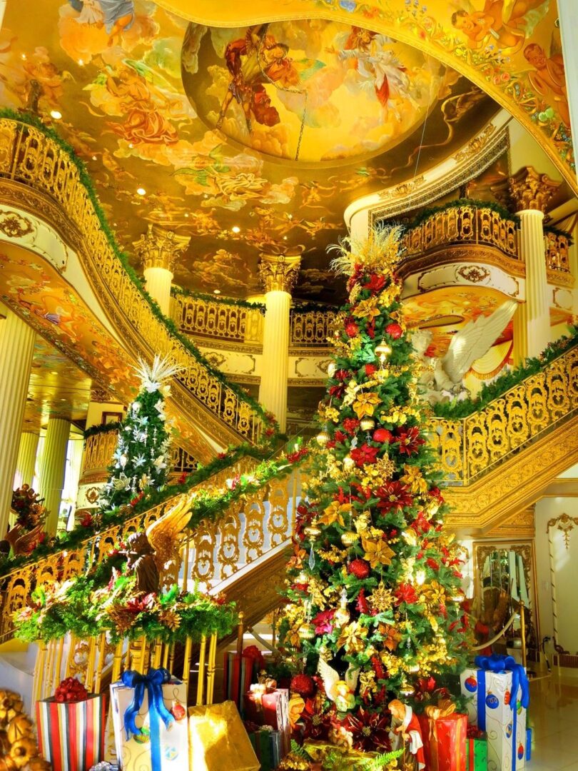 A christmas tree in the middle of an ornate staircase.