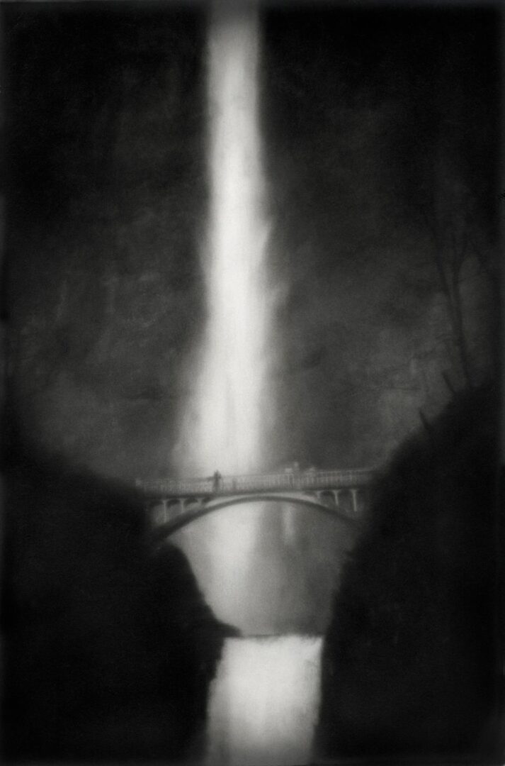 A black and white photo of a waterfall with a bridge.