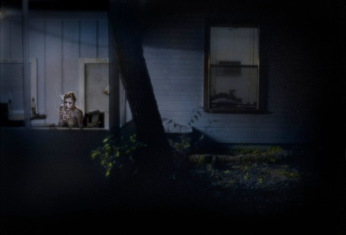A person sitting in front of a window at night.