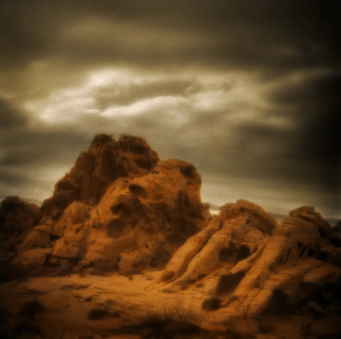 A desert landscape with rocks and clouds in the sky.